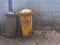 Plastic waste full of garbage bin dirty green and yellow on dirty light blue of wall