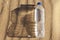 A plastic water bottle lies on the sand casting a wide shadow, the concept of plastic pollution