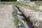 Plastic water pipe lying along the ditch with high groundwater, water connection in the housing estate.