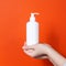 Plastic white antiseptic bottle with a dispenser on a orange background.