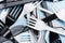 Plastic white and black forks and knives on a blue background. Concept plastic dishes, plastic pollution. Flat lay, top