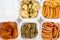 In plastic white containers there are dried fruits in sliced, persimmon, kiwi, apple, orange and grapefruit, close-up