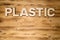 PLASTIC word made of wooden block letters on wooden board