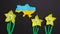 Plasticine stop motion animation, beautiful yellow plasticine blooming narcissus flowers next to a patriotic cut out map