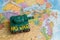 A plasticine tank on the background of a world map, as a symbol of peace and goodness. There is no war appeal. Stop war