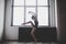Plasticity slim woman dancing near window. Professional dancer enjoy dance. Lady Dancer Training Modern Ballet In Class.