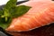The plate with appetizing salmon and the sprig of basil