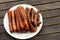 Plate of barbequed sausages on wooden table