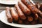 Plate of barbequed sausages on wooden table