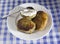 A plate with a Belarusian dish potato pancakes with meat filling and sour cream. Blue checkered background, kalduny