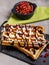 Plate of belgian waffles with chocolate sauce and currant fruit