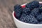 Plate with blackberries. Blackberries on wooden background. Sweet, ripe blackberries in bowl