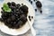 Plate with blackberries and blueberries on blue wooden background