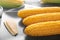 Plate with boiled corncobs and butter on plate, closeup