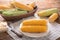 Plate with boiled corncobs on wooden table