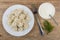 Plate with boiled dumpling, dill, bowl of sour cream