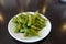 A plate of boiled green soybeans on table. A common side dish in Taiwanese restaurants.