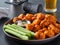 Plate of boneless chicken wings with buffalo sauce and celery sticks