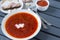 Plate of borscht with sour cream, pieces of lard, not a wooden background