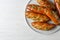 Plate of bread loaves with garlic and herbs on white wooden table. Space for text