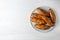 Plate of bread loaves with garlic and herbs on wooden table, top view. Space for text