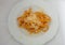 plate of bucatini amatriciana with a drop of pecorino cheese