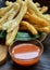 A plate of Cakwe or Cakue with chilli sauce at wooden table. Cakwe is a popular traditional snack from Chinese and indonesia.