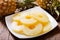 Plate of canned slices of pineapple and fresh pineapple