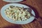 On the plate capital salad.Mayonnaise salad. Food background - salad olivier close-up. Green peas, cucumber, potatoes, sausage,