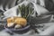 A plate of cheese with garlic, rosemary and pepper with a glass bowl of asparagus on a satin background