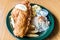 A plate with chicken tender, french fries, and mashed potatoes with a lemon on top