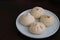 A plate of Chinese pan-fried pork buns Sheng Jian Bao on table