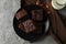 Plate with chocolate cake slices, almond and bottle of milk on grey background