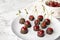 Plate of chocolate dipped cherries on marble table