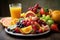 plate of colorful fruits and veggies, with a glass of juice in the background