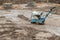 Plate compactor on the ground at construction site. Vibratory hammer power tool, jumping jack machine compressing ground