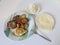 Plate with cooked potato, meat, egg next to plates with cheese and sauecraut..
