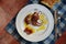 A plate of cooked small polyp and lemons garnished in olive oil on a ceramic table with old cutlery photographed from above