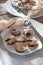 A plate with cooked snails on a wooden table.