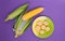 A plate with corn on a purple background