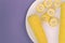 A plate with corn on a purple background