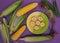 A plate with corn on a purple background