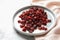 Plate with cranberries on marble table. Dried fruit