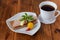 Plate with crispbread, cheese, ham, cherry tomato, cup of coffee on a wooden background. Healthy breakfast. Healthy