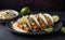 A plate of crispy fish tacos with cabbage slaw and lime