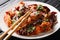 Plate of crispy mala chicken smothered in chili peppers, Sichuan peppercorns close-up in a plate. Horizontal