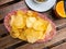 Plate of crispy potato chips served with glass of red vermouth