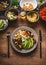 Plate with cutlery and various salad meals . Vegetarian salad bar with variety of vegetarian food bowls, top view. Healthy eating