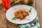 Plate of delicious authentic Hungarian goulash with berry drink on wooden table