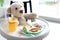 Plate with delicious baby food, drinking cup and teddy bear